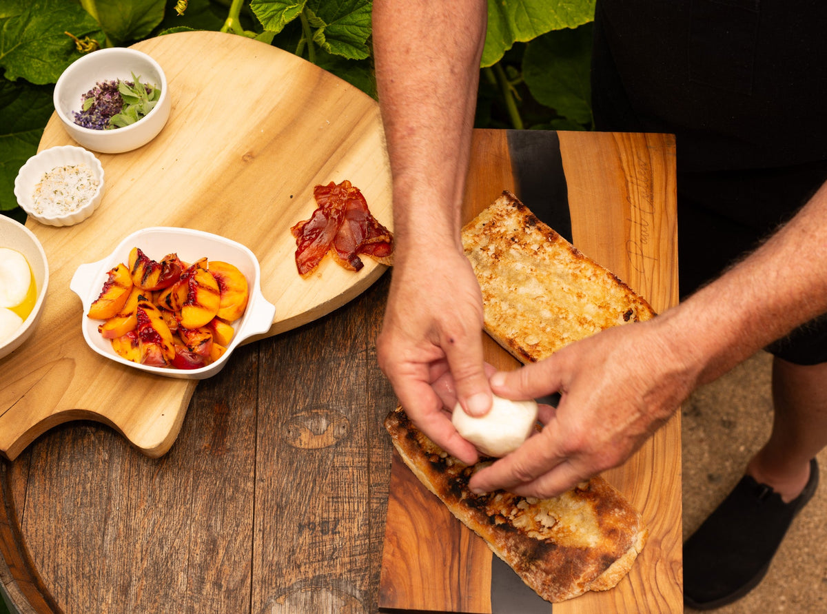 Grilled peach crostini with burrata being prepared