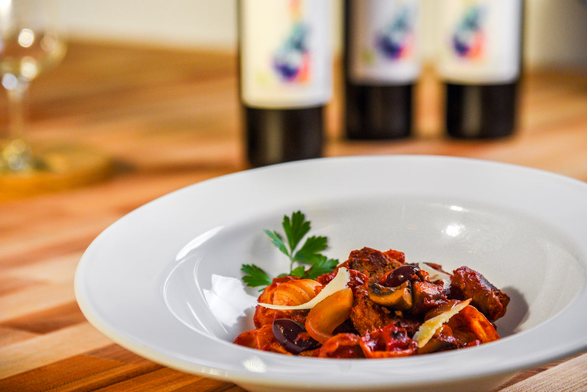 A pasta dish at Paul Cullen’s table with wine in the background