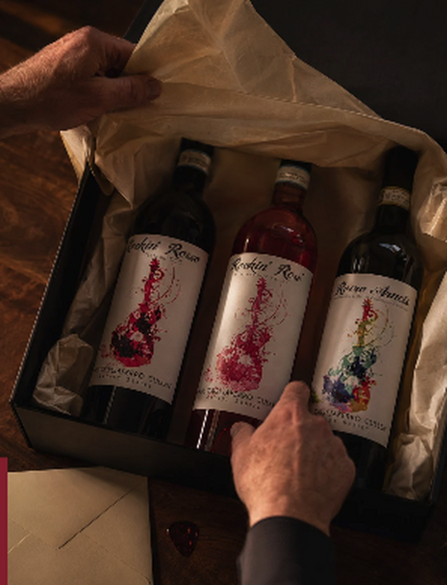 A hand revealing three Paul Cullen wine bottles packed inside a box